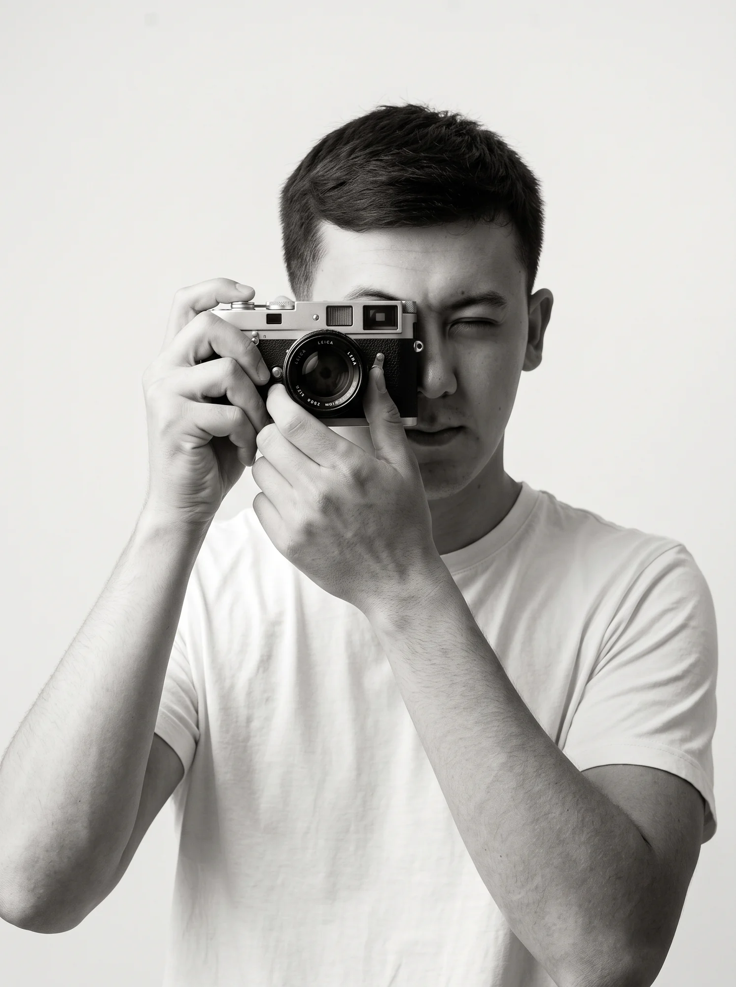 Javohir Tirkashov looking through the viewfinder of a camera
